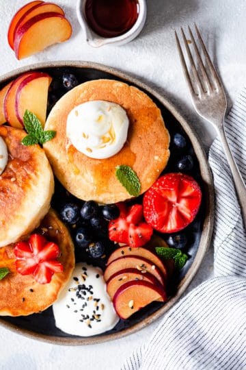 top view of a plate with pancakes and fruits.