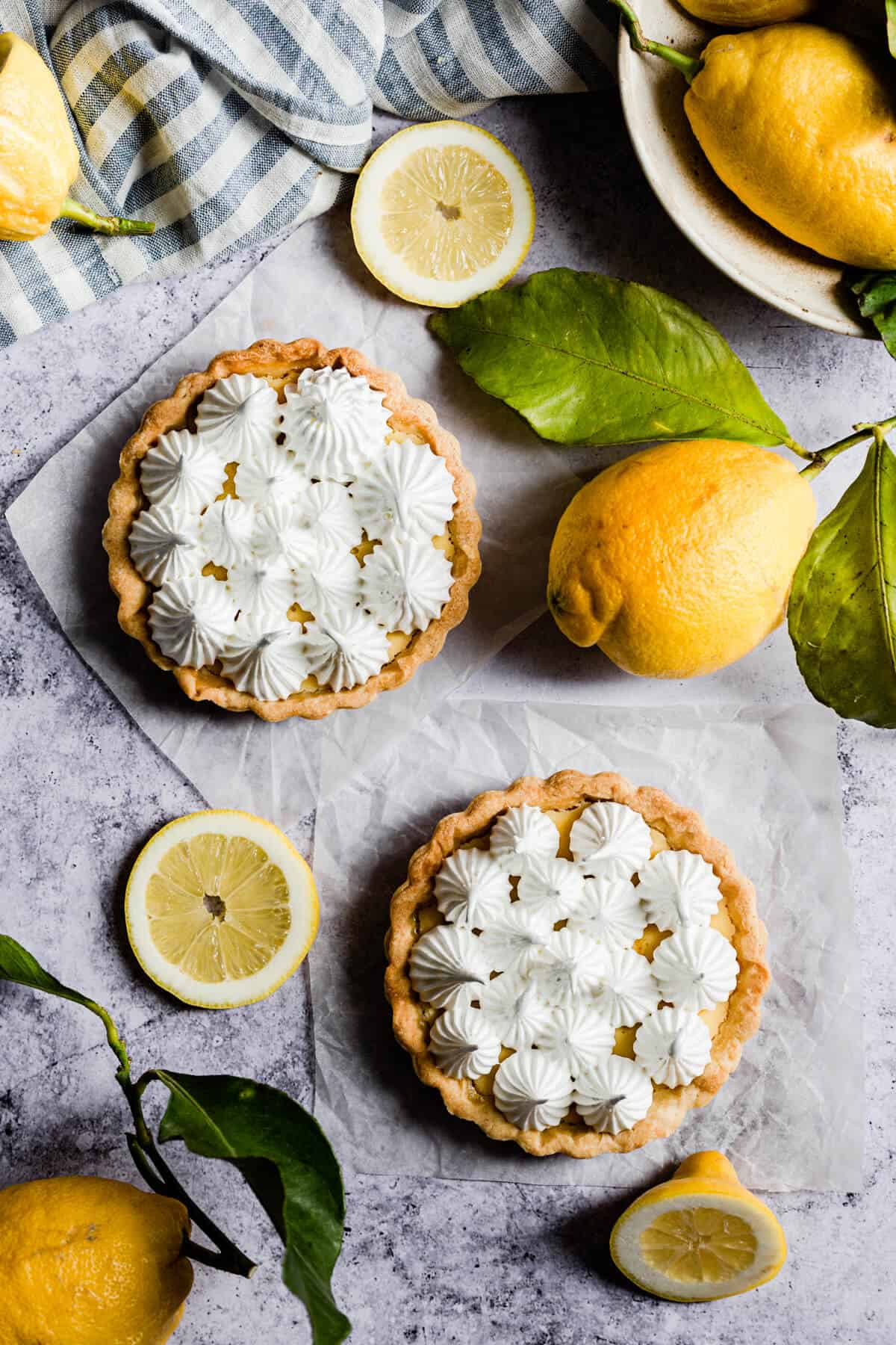 overhead shot of two small lemon pies topped with meringue