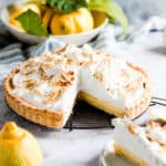 side view of a lemon pie with a slice cut out