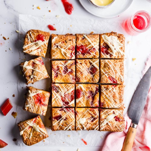 top view of square slices of blondies topped with rhubarb and custard