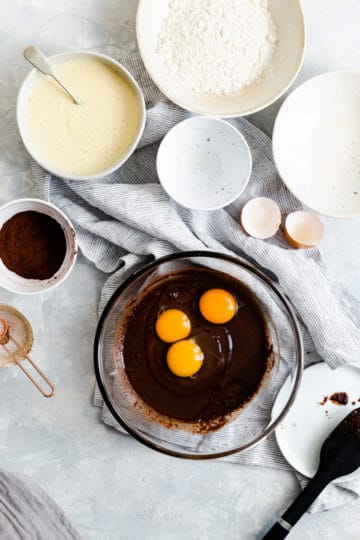 overhead shot of a bowl with brownie batter and some eggs on top