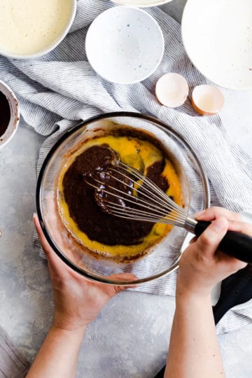 top view of a person whisking eggs into brownie batter