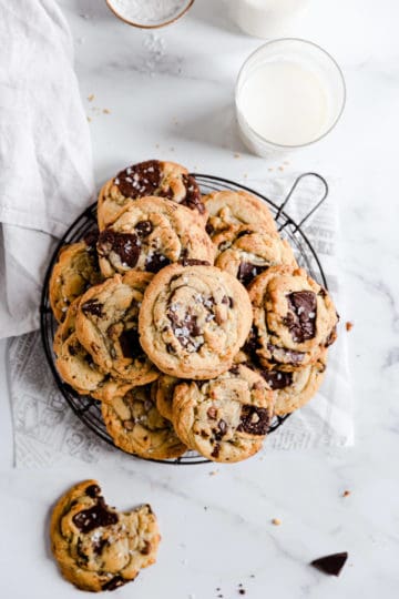 overhead shot of cookies on a round wire rack with glass of milk