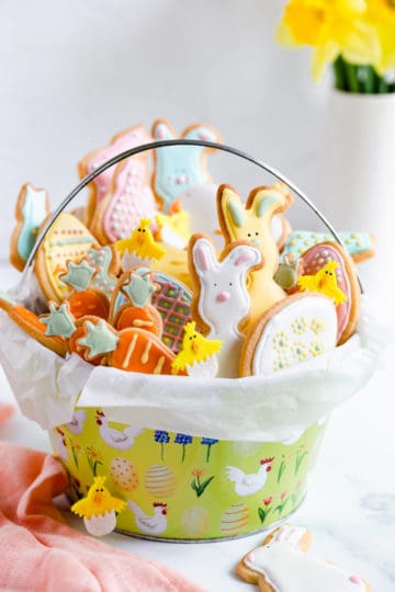 side close up of basket filled with Easter sugar cookies with coloured icing