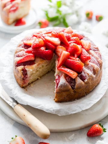 top side angle of fresh strawberry yogurt cake with slice cut out