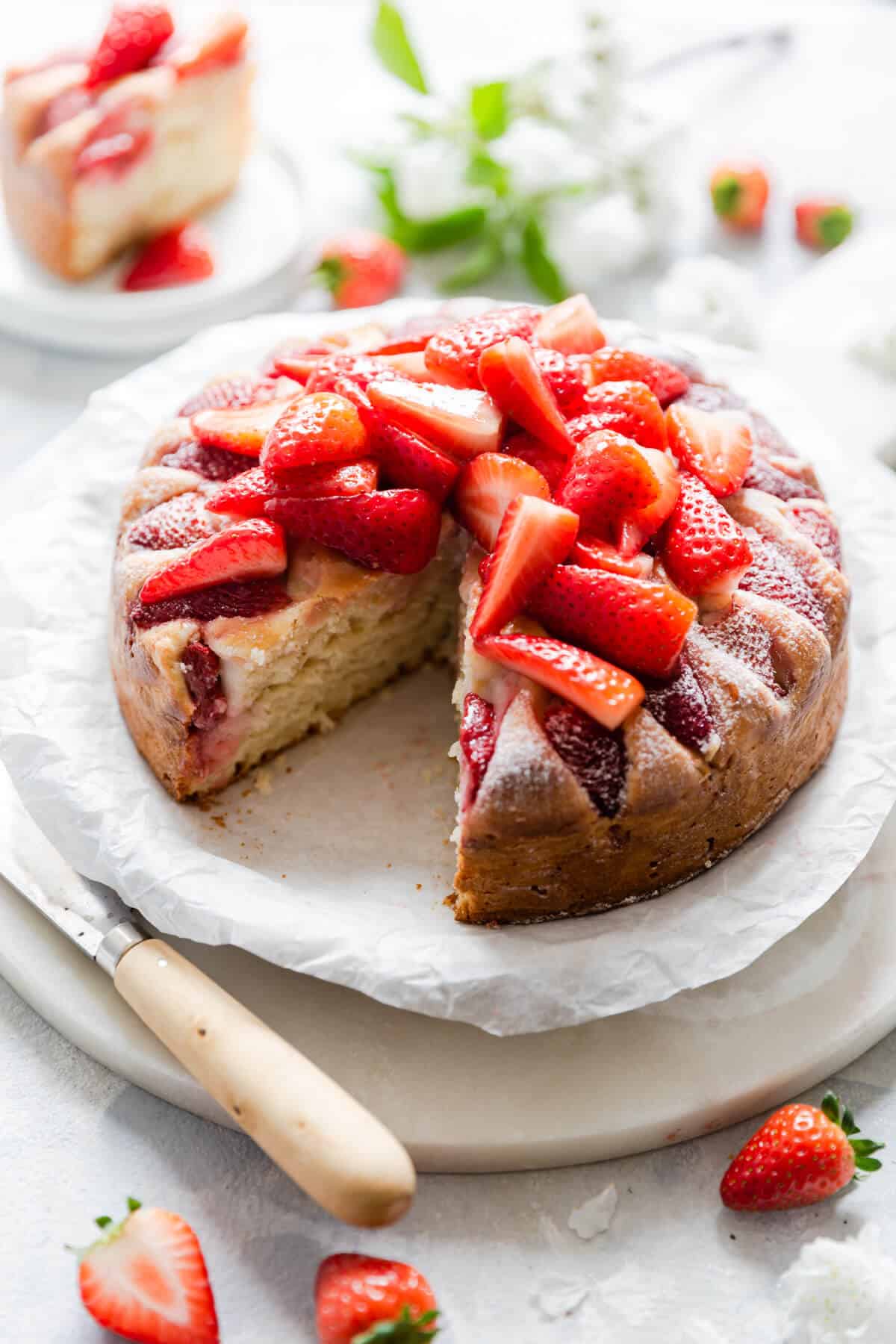 top side angle of fresh strawberry yogurt cake with slice cut out