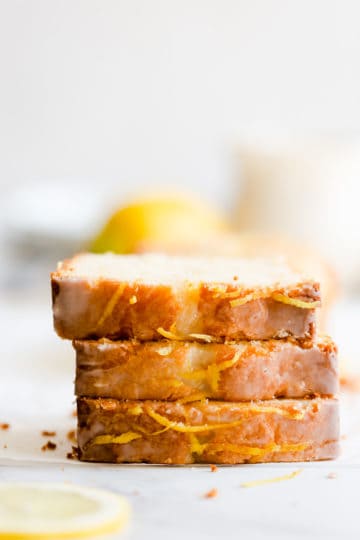 side close up of three slices of lemon drizzle cake stacked on top of eachother