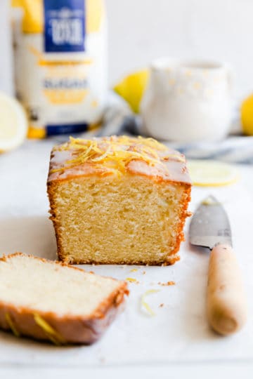 side close up at small batch lemon drizzle cake with a slice cut off