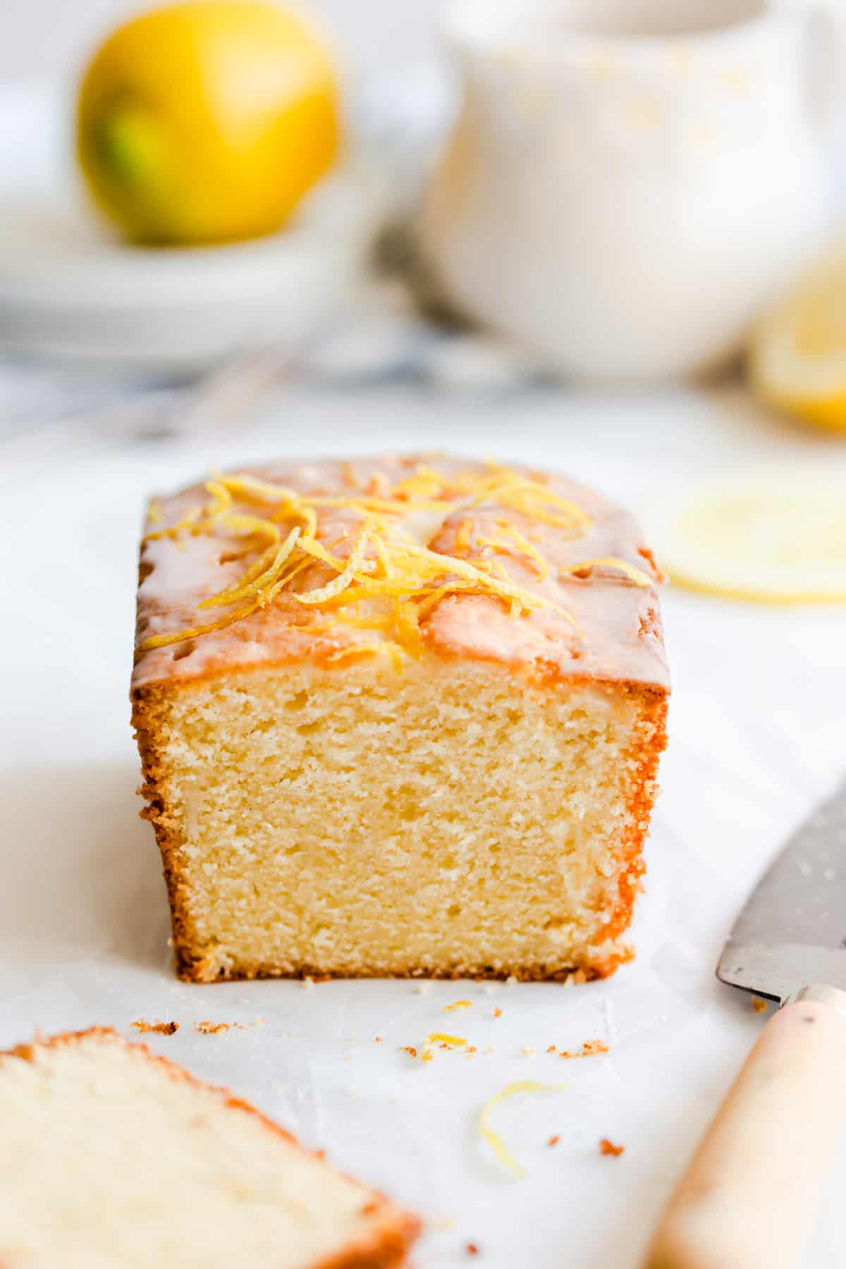 straight ahead shot of lemon drizzle cake with slice cut off