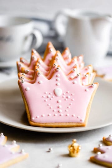 side close up shot of crown shaped sugar cookies with pink icing