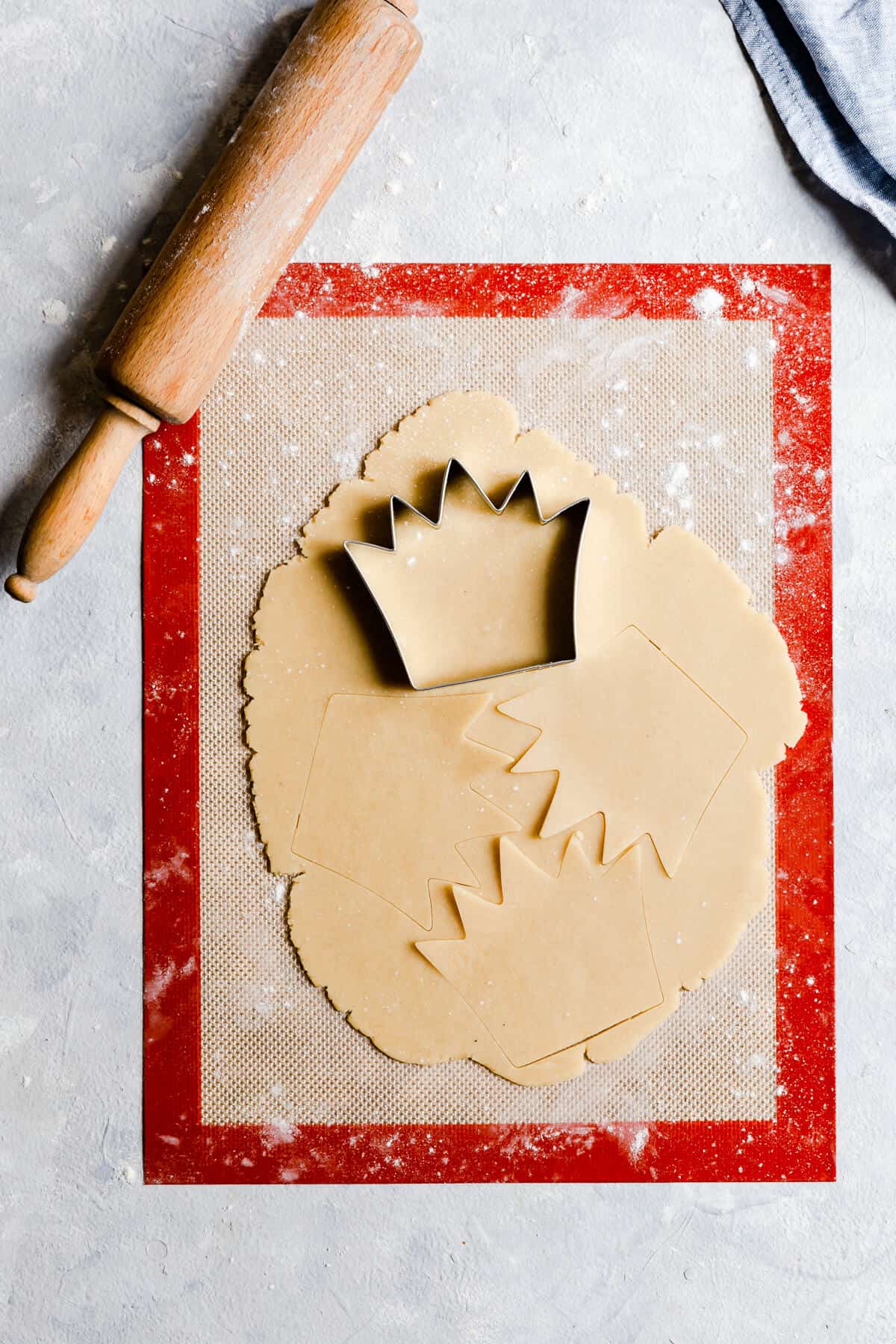 overhead view process shot of rolled cookie dough with crown cookie cutter on top