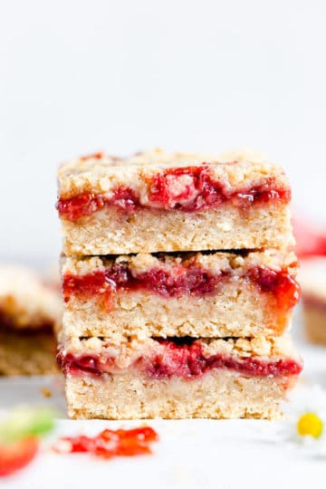 straight ahead angle super close up of 3 strawberry crumble bars stacked on top of one another