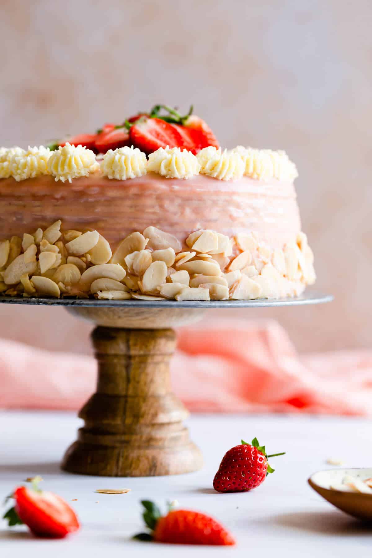 straight ahead close up of strawberry crepe cake on a cake stand