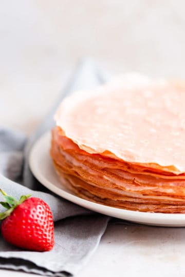 side close up of pink crepes on a plate