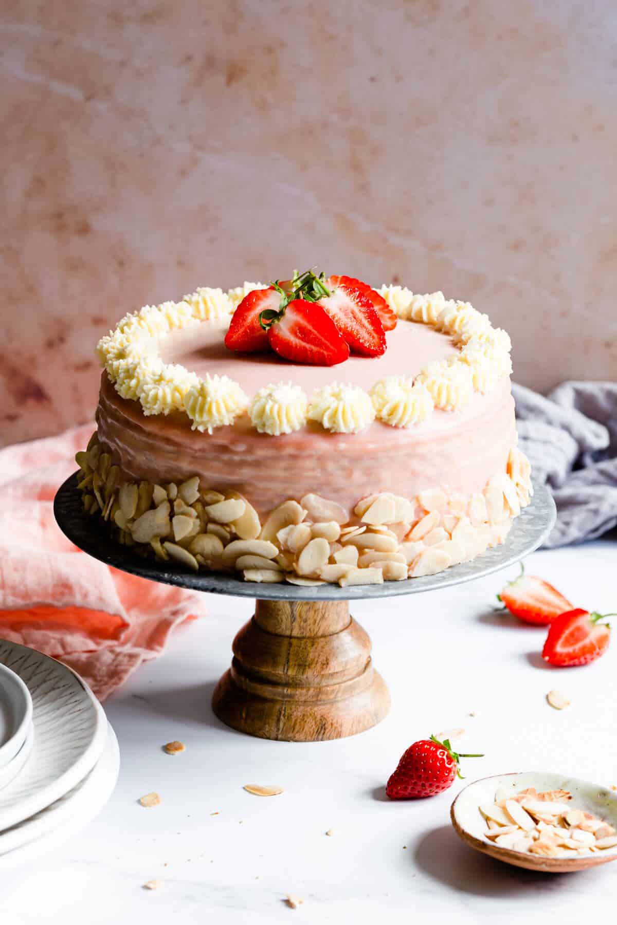 side close up of a strawberry crepe cake topped with fresh strawberries