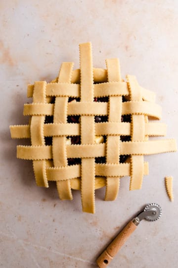 overhead shot of a unbaked pastry lattice on top of the cherry filling