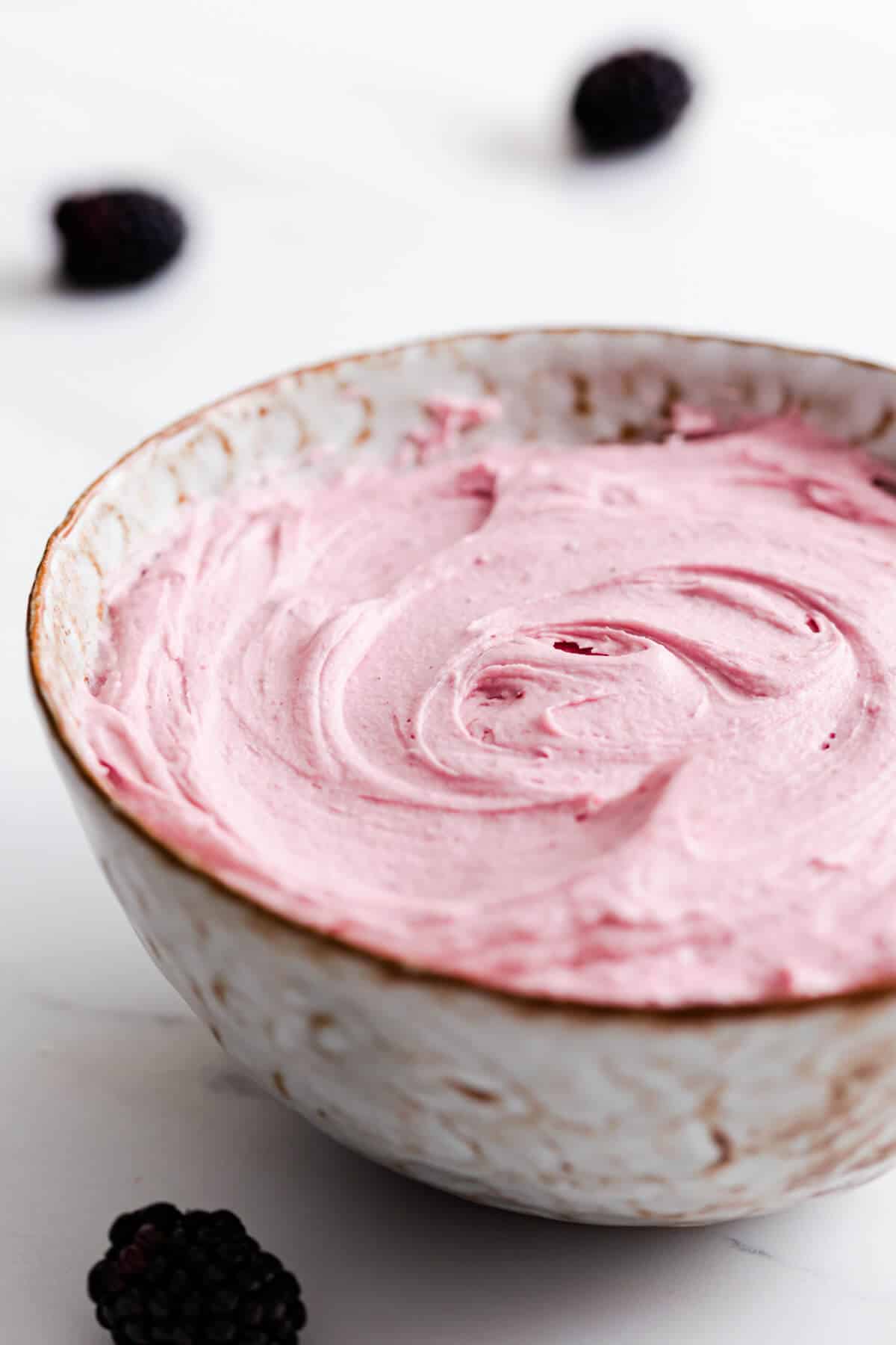 side super close up of a bowl with blackberry buttercream