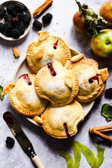 top view of a plate with 5 apple and blackberry hand pies