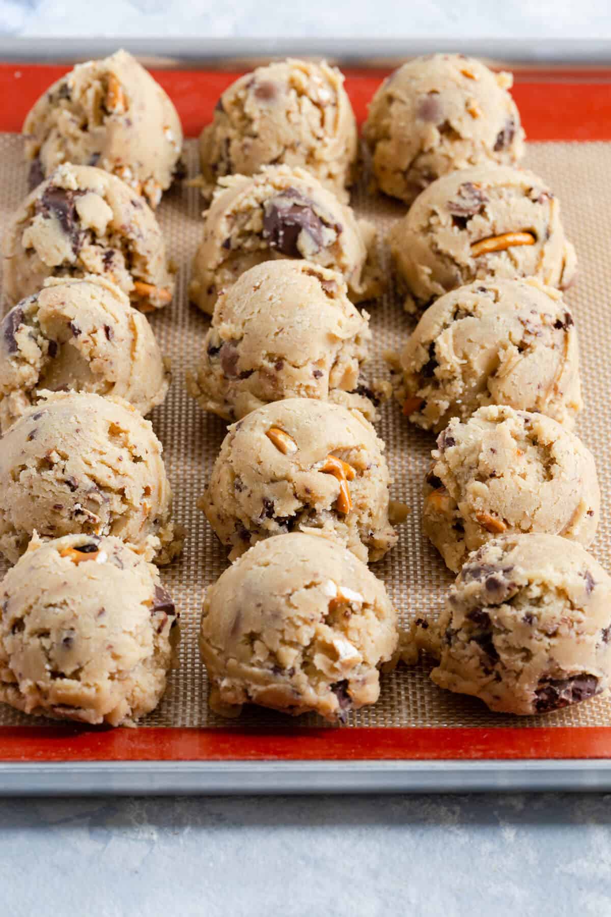 side close up of balls of cookie dough on a baking silicone mat