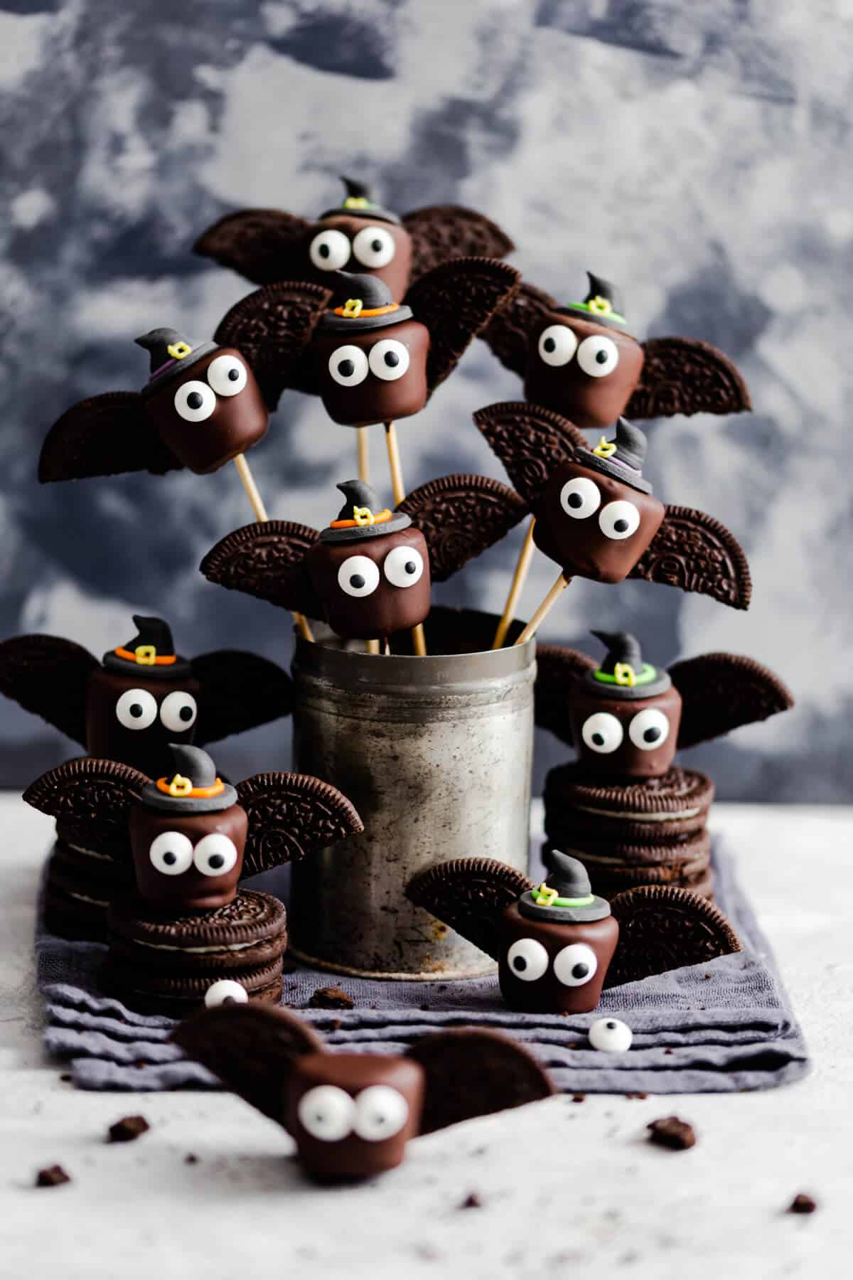 side angle of chocolate marshmallows looking like little bats on bamboo skewers