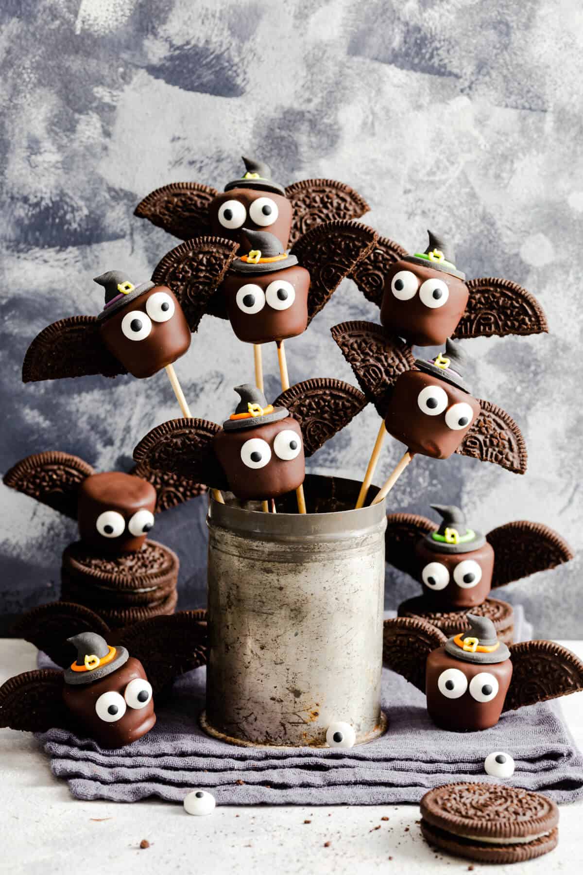 side shot of chocolate bats on bamboo skewers in a little cup