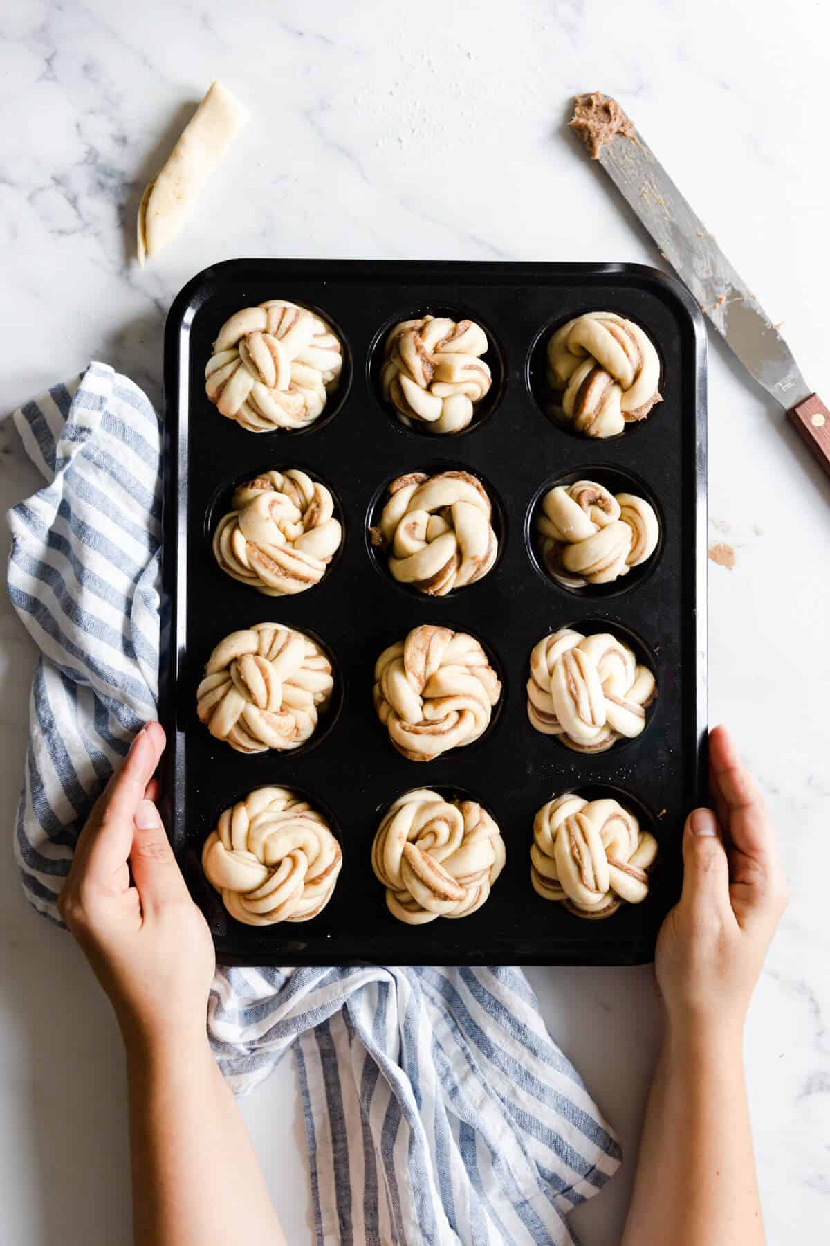top view of a muffin tray filled with unbaked cinnamon buns
