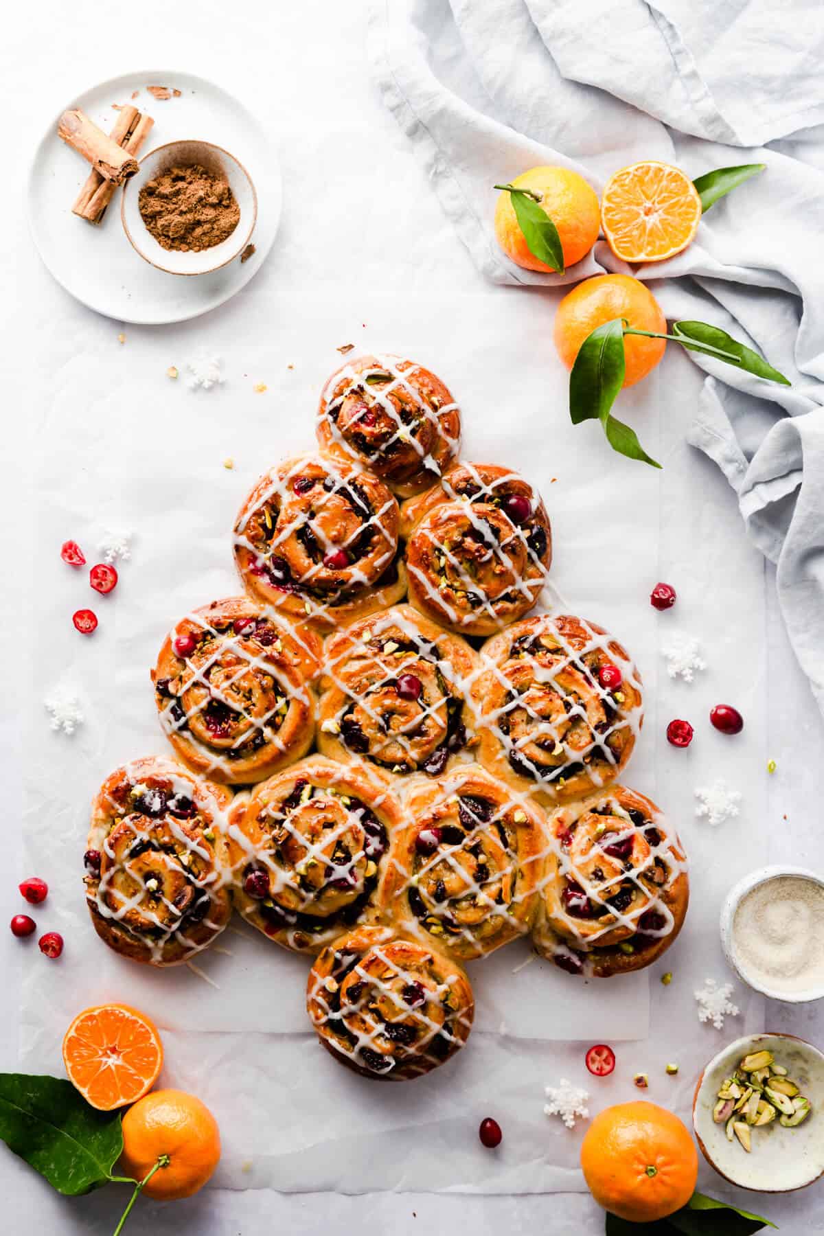 overhead shot of orange and cranberry Chelsea buns shaped into a Christmas tree