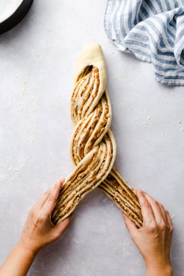 top view of a person twisting the dough for cinnamon and hazelnut bread