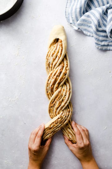 top view of a dough being twisted for cinnamon and hazelnut bread