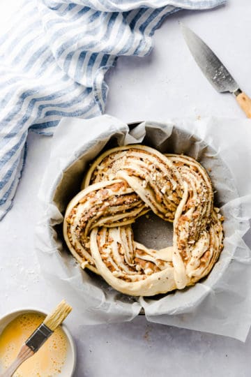 top view of twisted cinnamon and hazelnut bread in a baking tin with baking paper