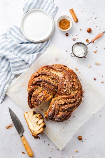 overhead shot of a twisted cinnamon and hazelnut bread with a slice cut out on side