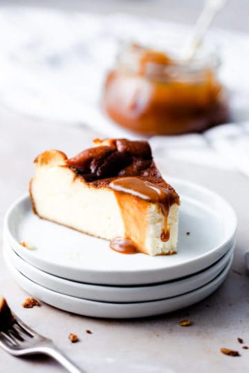 an individual slice of burnt Basque cheesecake with some caramel sauce dripping from top.