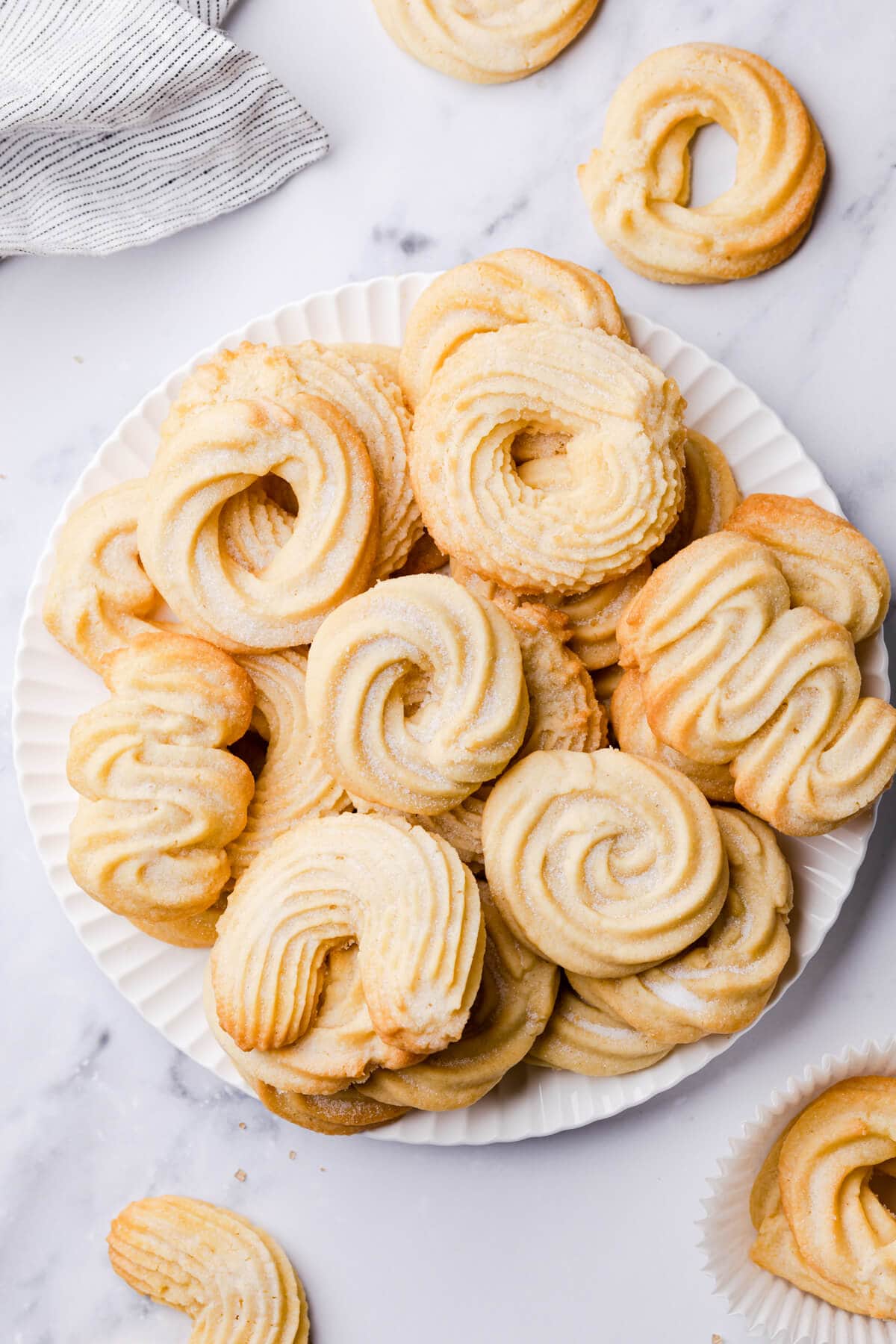 selection of Danish style butter cookies in different shapes on a white plate.