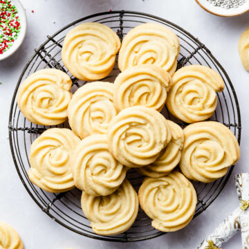 plain butter cookies piped into rosettes on a white background.