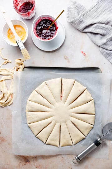 overhead shot of a dough circle with 16 strips cut outs