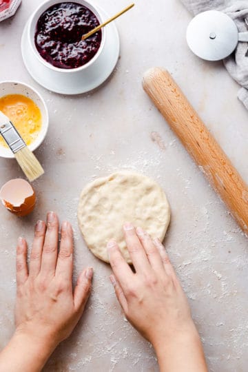 overhead shot of a person shaping some dough into a circle