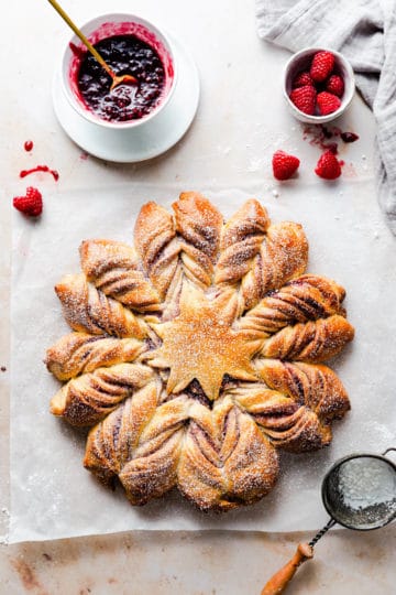 top view of a raspberry star bread dusted with icing sugar