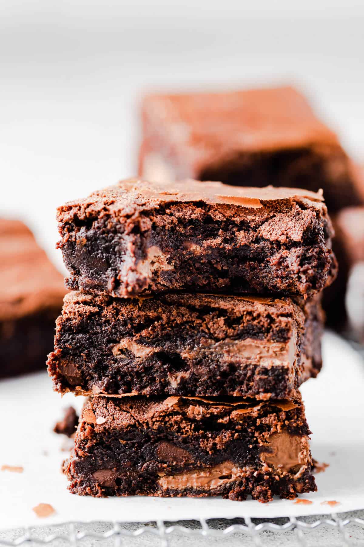 side close up at a stack of three brownies with the top one missing a bite