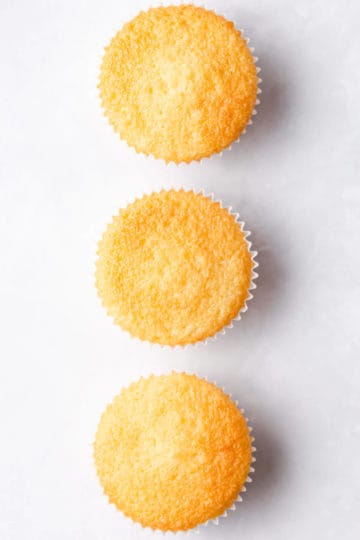 overhead view of 3 vanilla cupcakes with smooth and even tops