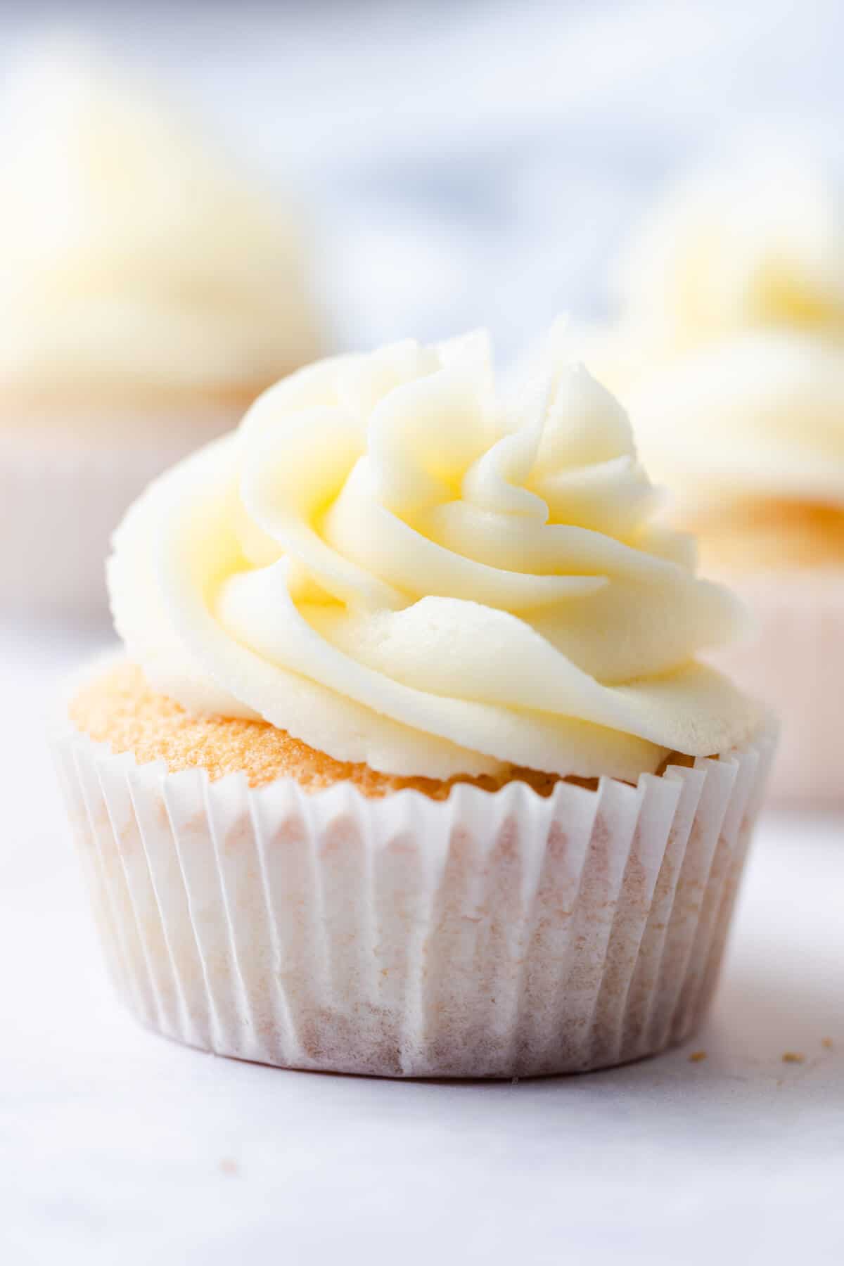 straight ahead super close up of vanilla cupcake topped with buttercream