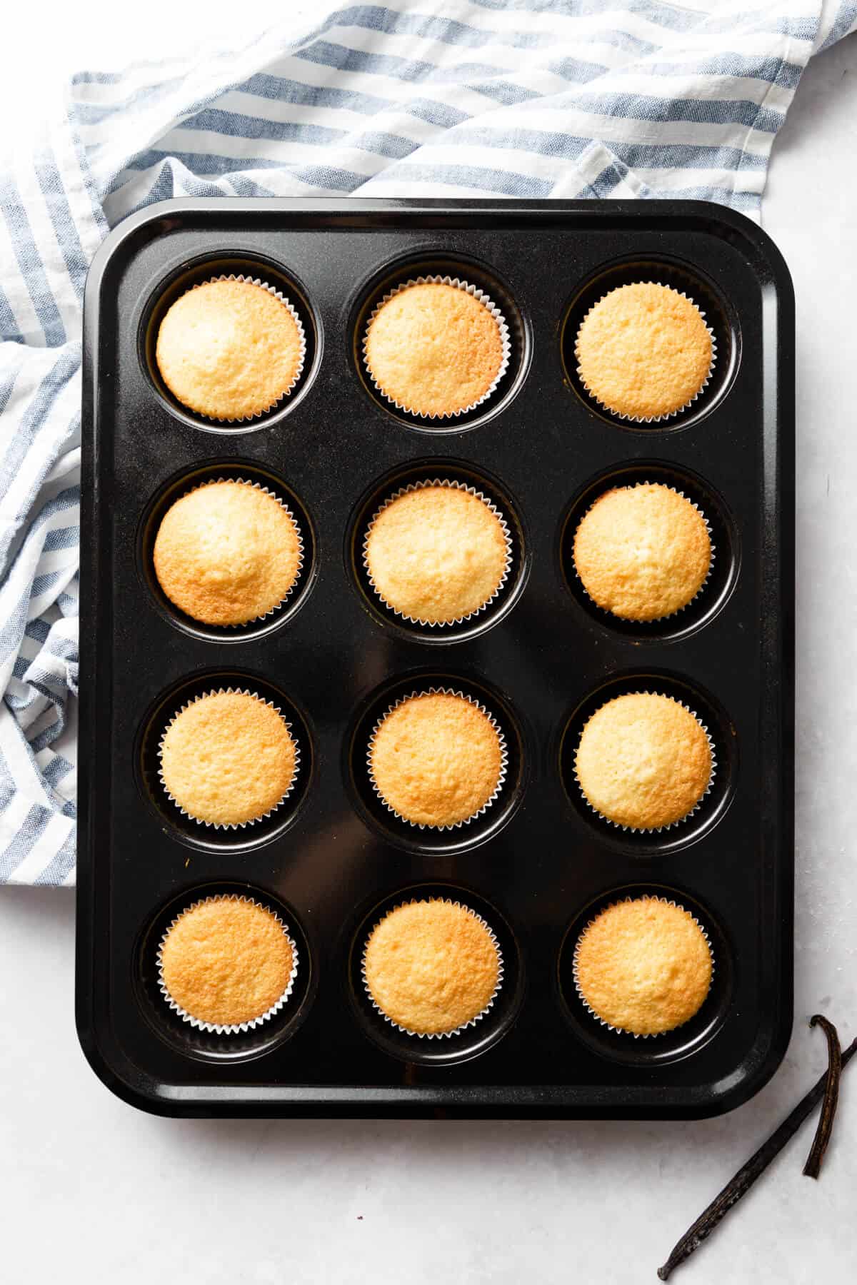 overhead shot of 12 vanilla cupcakes in cupcake baking tray
