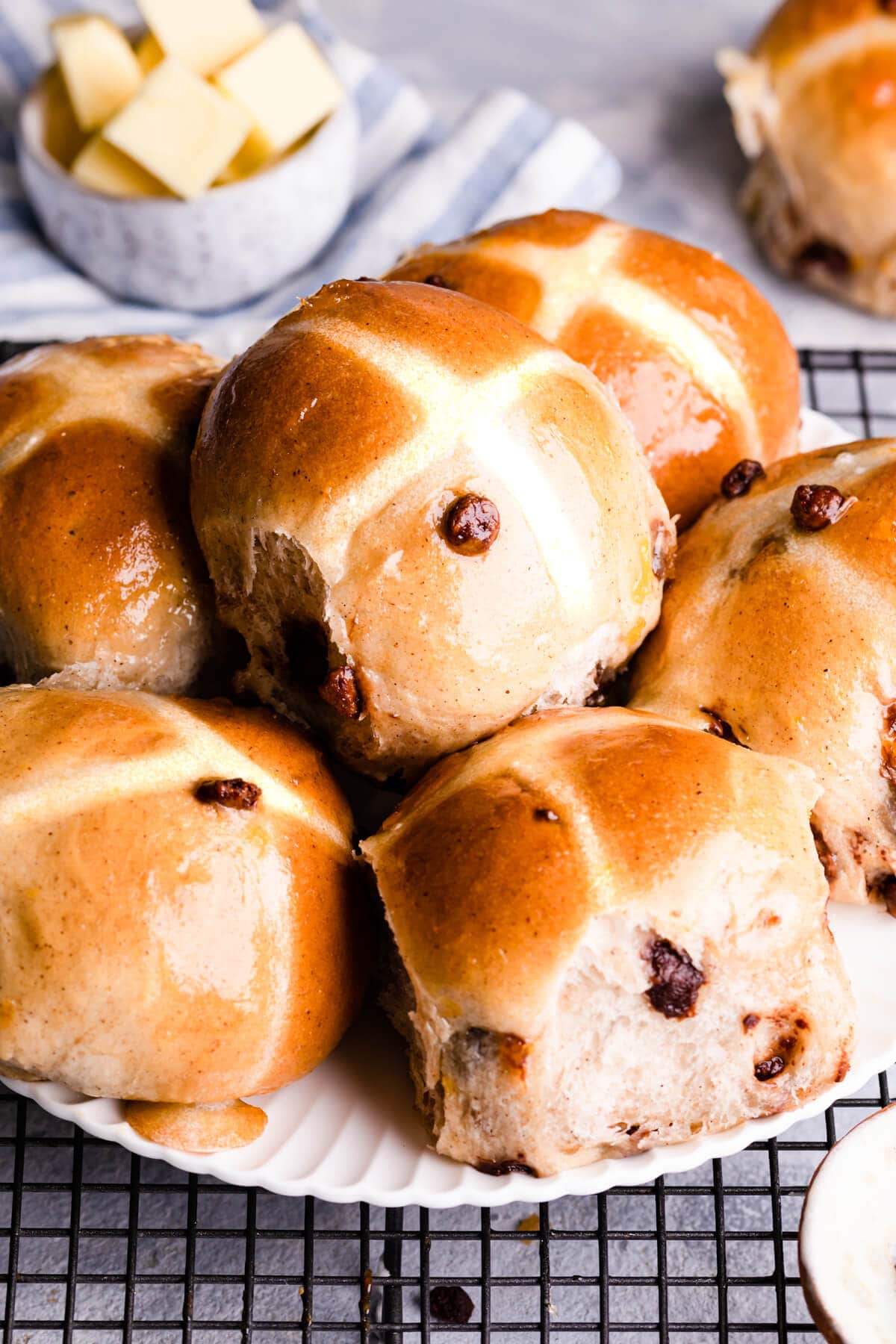side view of chocolate chip hot cross buns on a plate