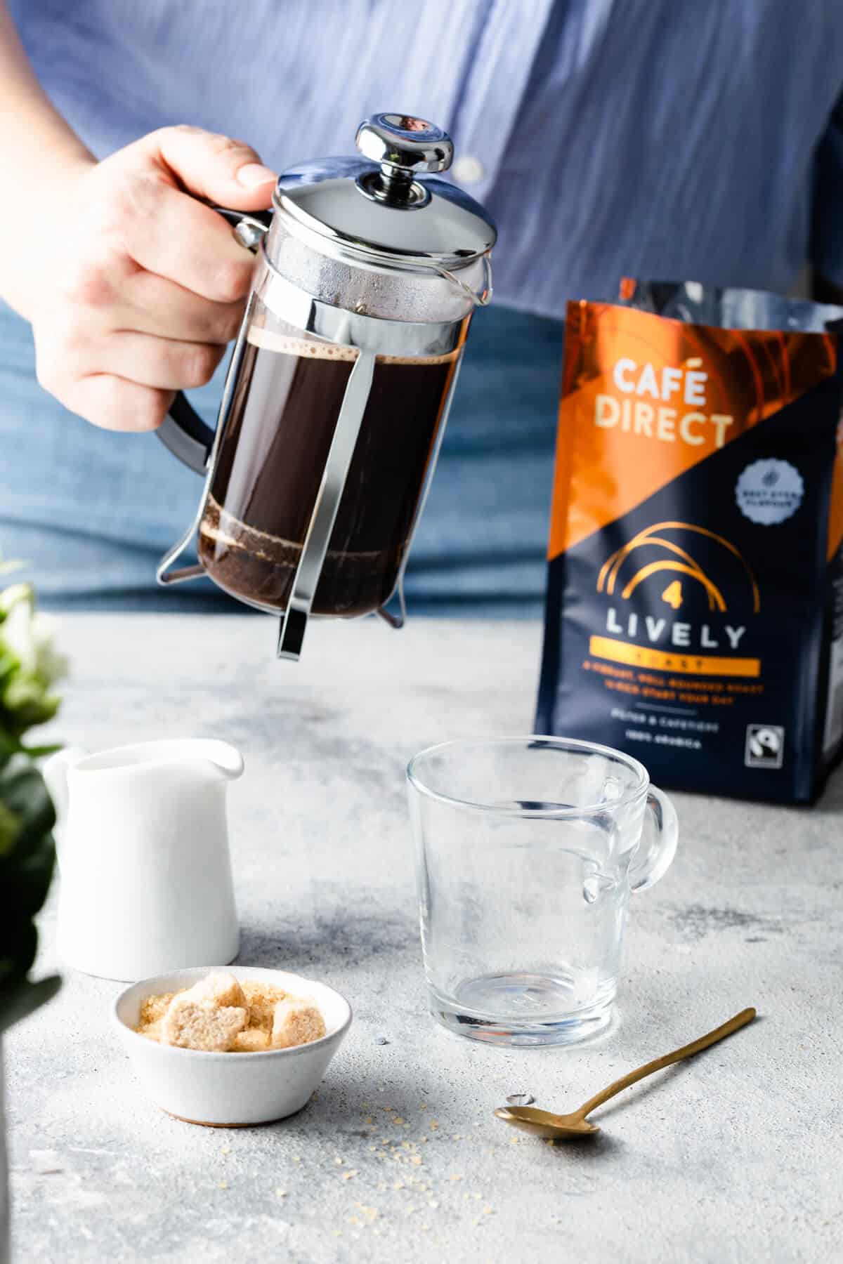 a person holding cafetiere with freshly brew coffee