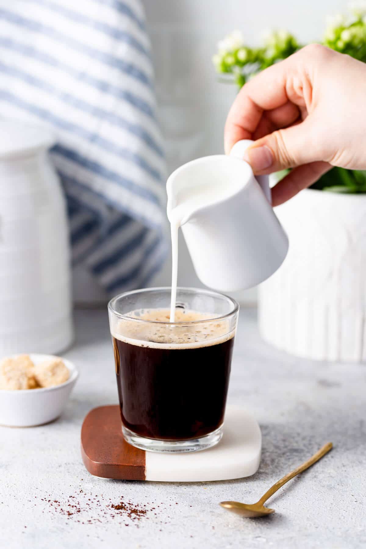 milk being poured into a cup of coffee