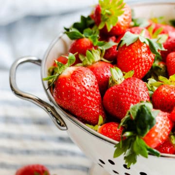 close up at fresh strawberries in a large sieve