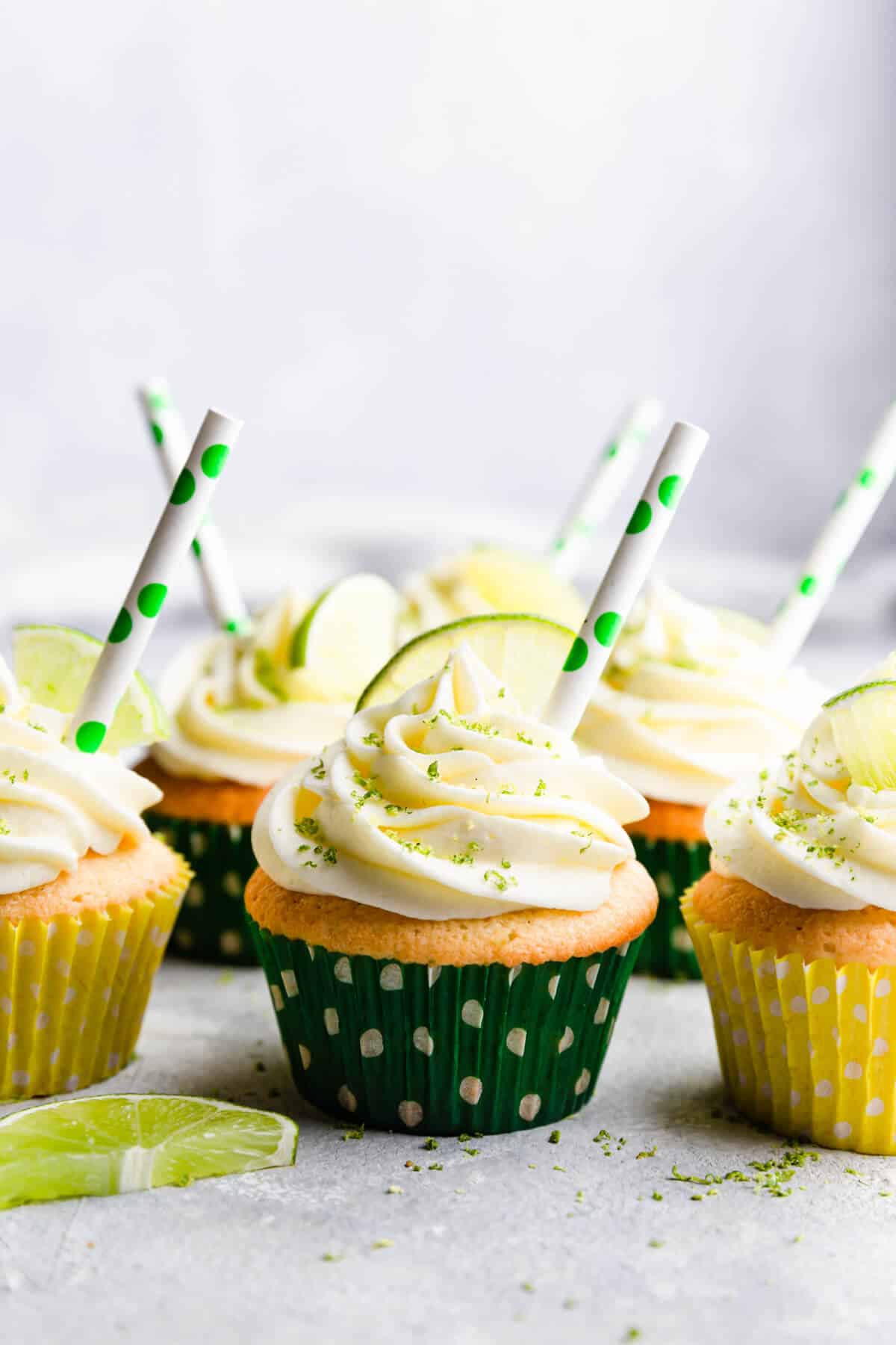straight ahead shot of gin and tonic cupcakes with paper straws in buttercream