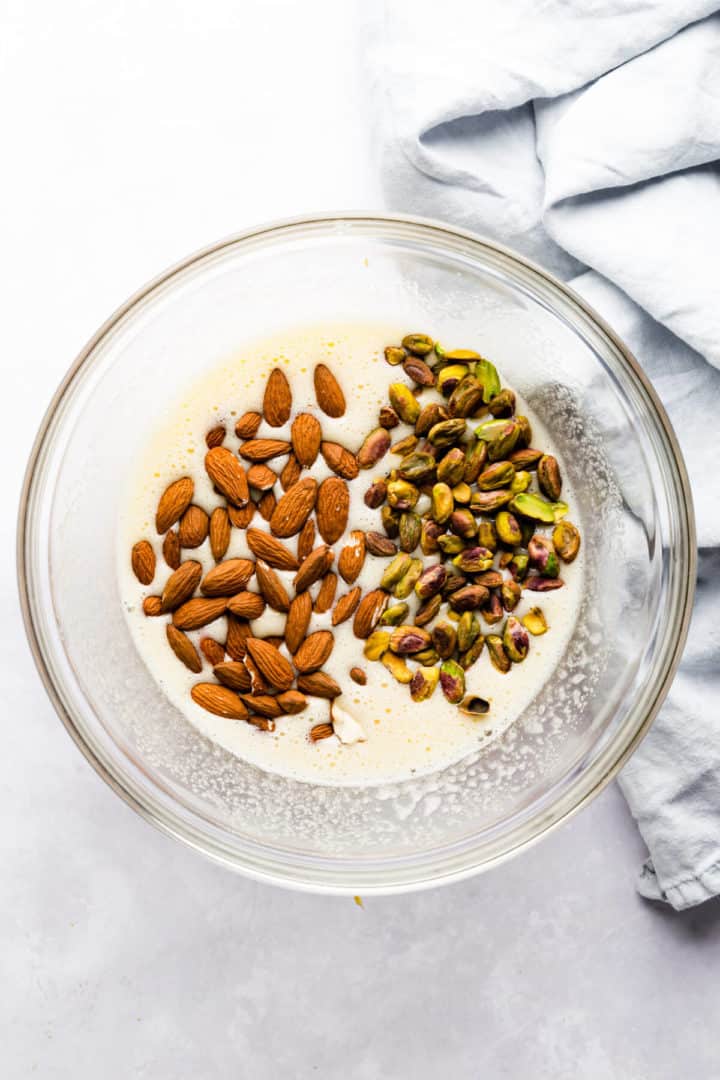 top view of a bowl with pistachios and almonds and whipped eggs