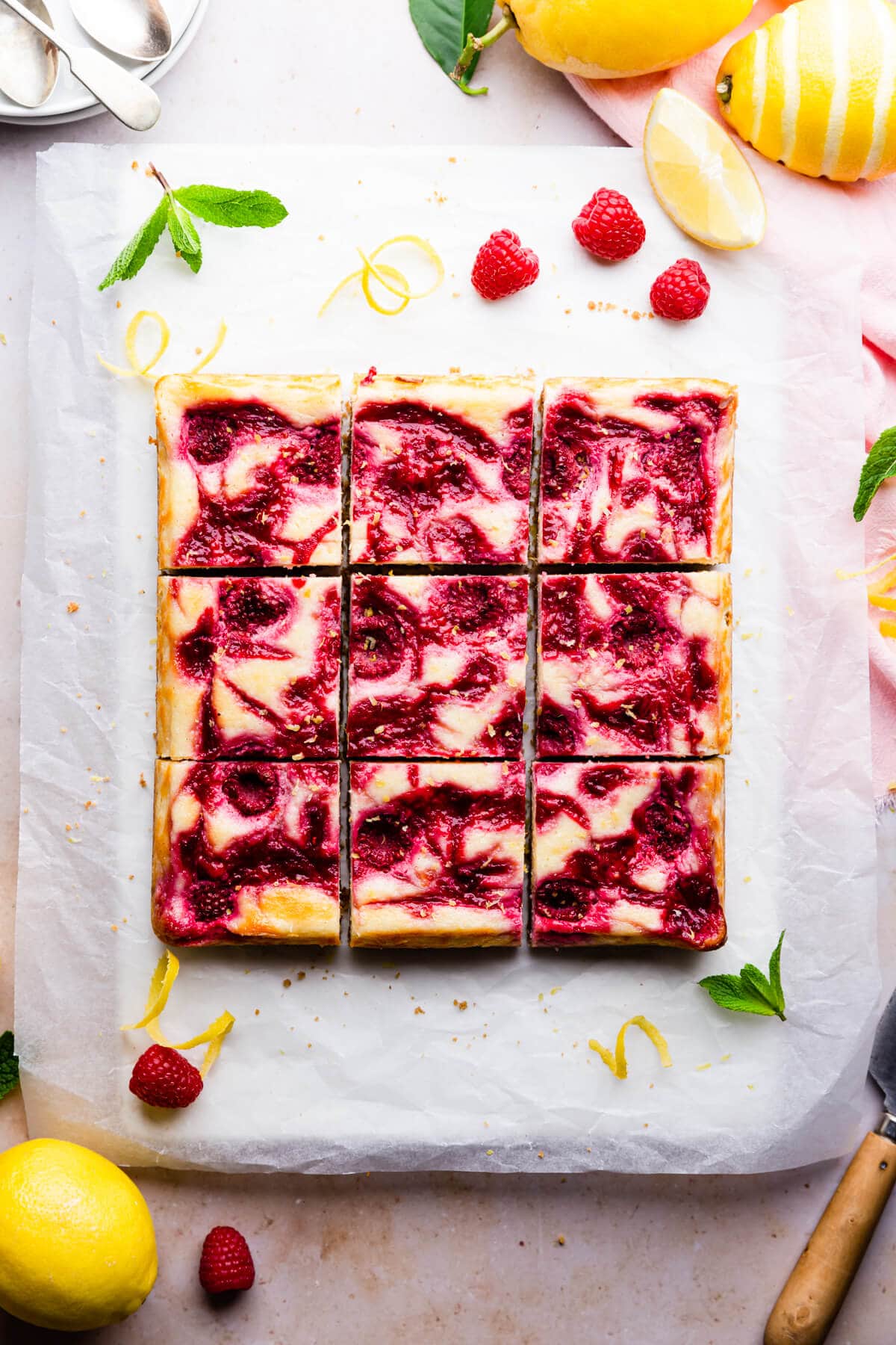 overhead shot of a 9 square slices of raspberry lemon cheesecake bars