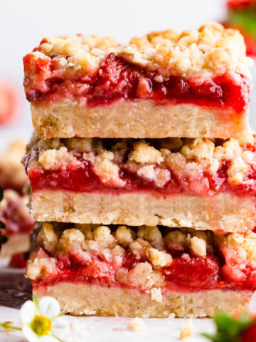 side super close up of a stack of three strawberry crumble bars.