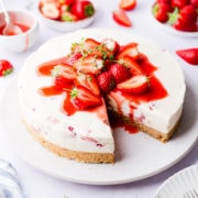 45 degree angle view of strawberry white chocolate cheesecake with a slice cut out